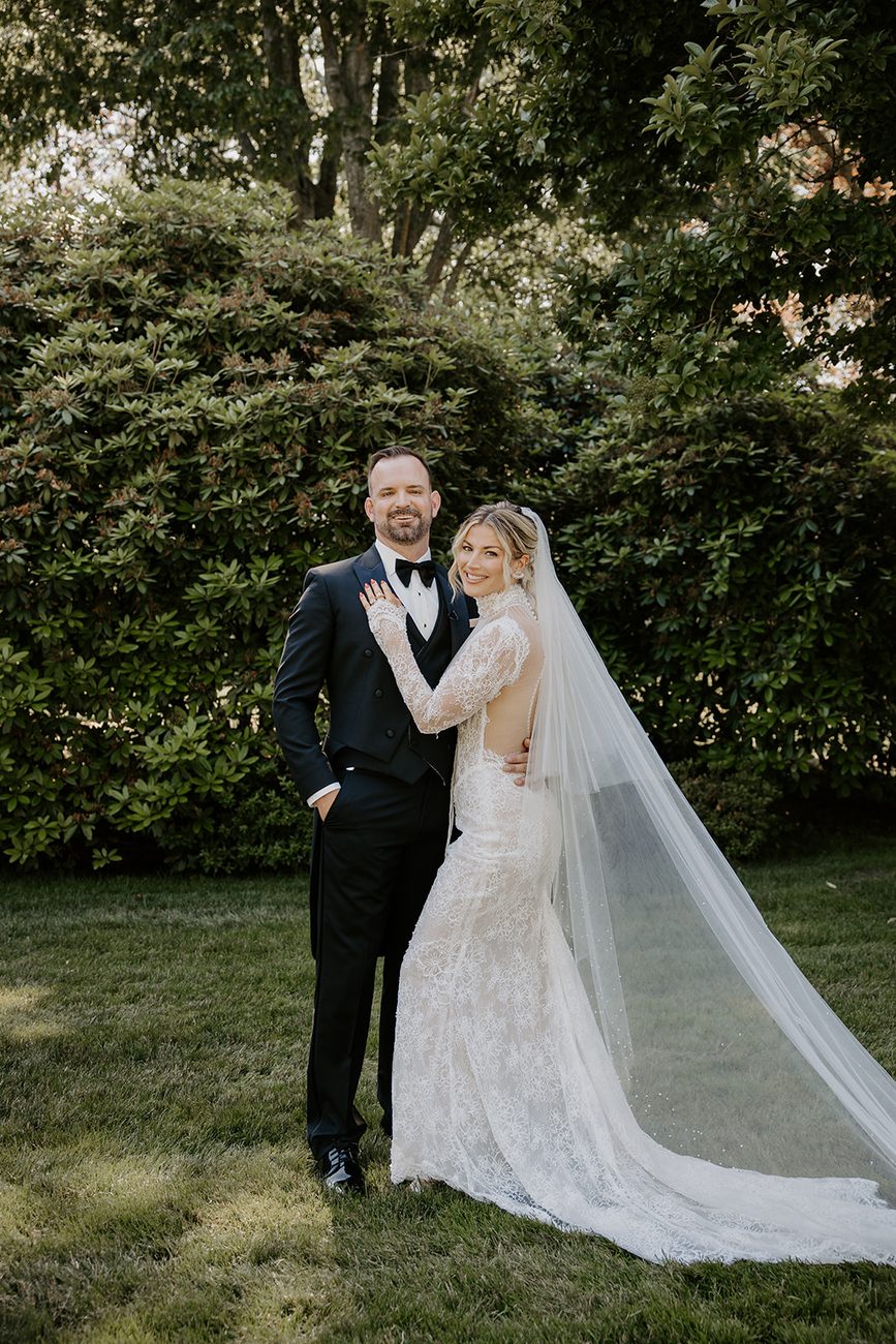 Jim and Anne posing together on the lawn at Glen Manor House, Portsmouth RI, her long veil trailing across the grass